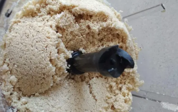 Smíchejte ve food procesoru všechny suché suroviny.  Přidejte máslo. Promixujte do hladké drobenky. Pokud nemáte food procesor, můžete tuk do těsta zamačkat vidličkou, až se rozdrobí. Nedělejte to rukama, těsto se spaří a není to ono. Snažte se pracovat co nejrychleji, aby se suroviny zbytečně nezahřály.
Pak přidejte žloutky a opět zapracujte. Těsto nechte odpočinout v lednici.