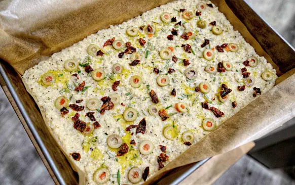 Ostatní ingredience smíchám dohromady a přidám květák zbavený vody.

Do plechu (35 cm x 25 cm) dám pečící papír a propracované těsto rozetřu na papír.